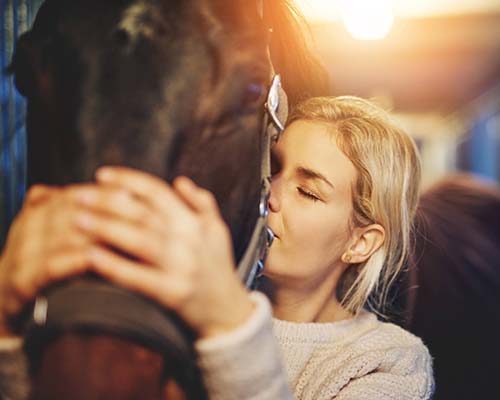 Pige krammer sin hest