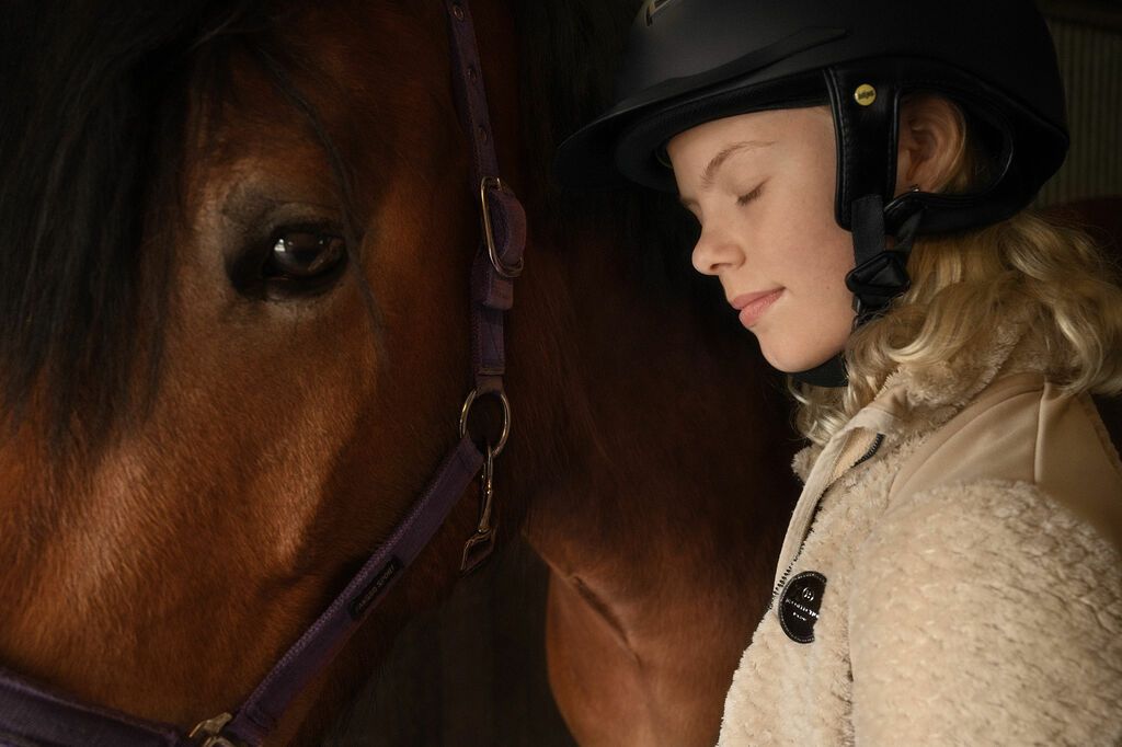 Pige står sammen med sin pony