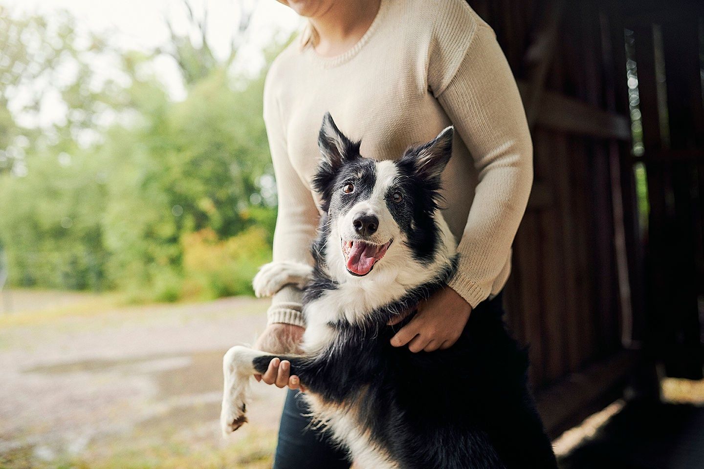 Kvinde står med sin hund 