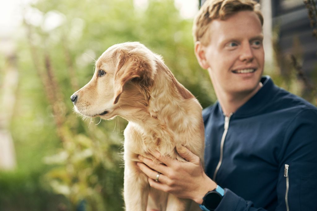 Mand sidder med sin hund på skødet