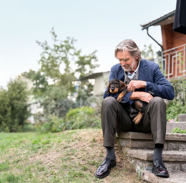 Kvinde ligger med sin hund i sofaen