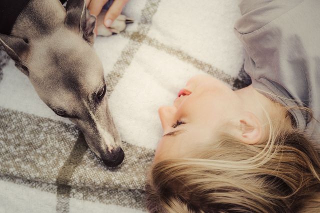 Kvinde og hund sover i en seng