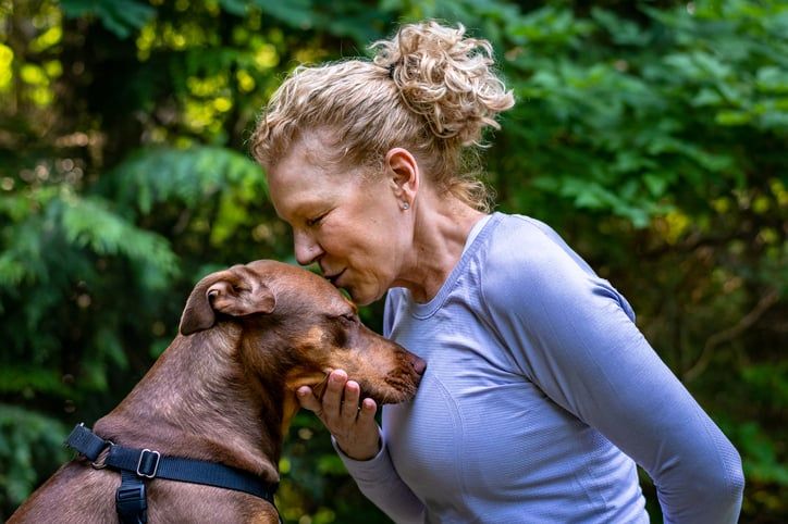 Kvinde kysser sin hund på hovedet