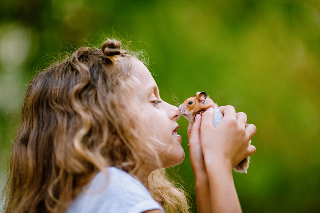 Pige nusser med sin hamster