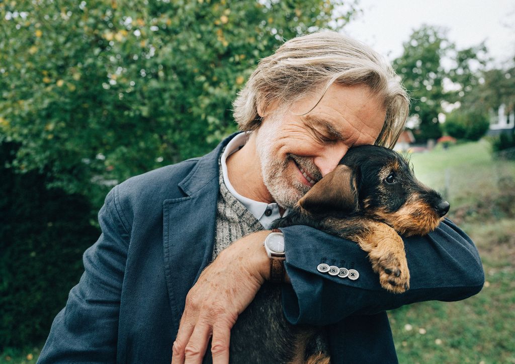 Mand krammer sin nye hundehvalp