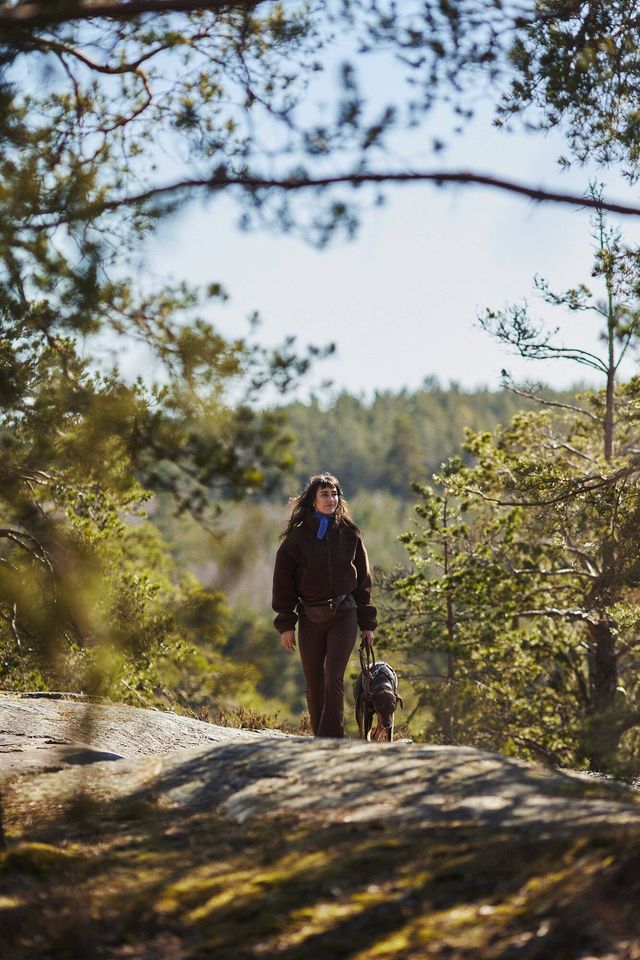 Ejeren går Agrias Hundegåtur med sin hund i skoven.