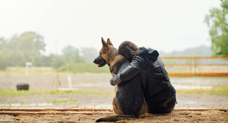 Pige krammer sin hund udenfor