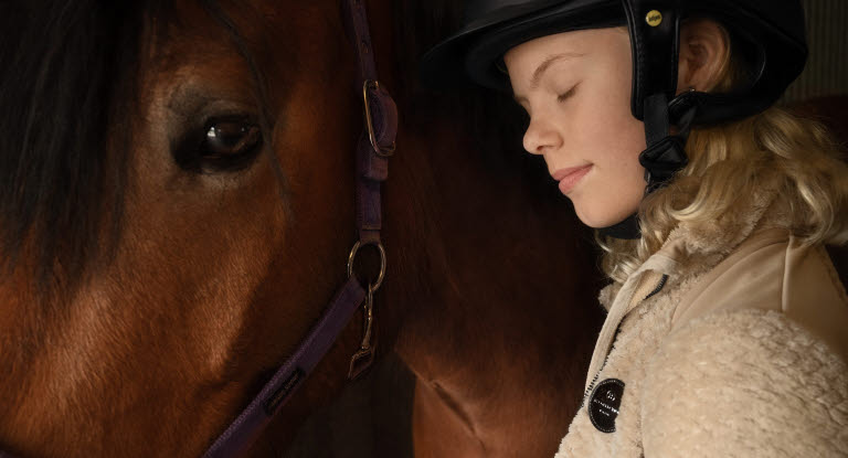 Pige står sammen med sin pony