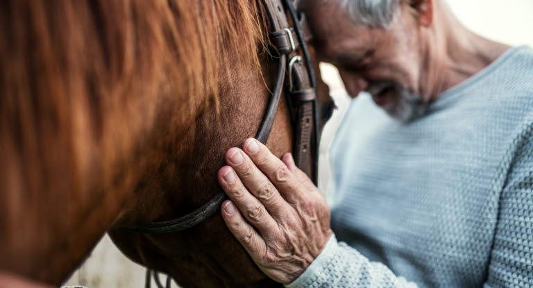 En mand krammer sin hest